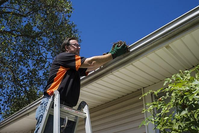 two workers fixing a gutter on a residential house in Bunnell