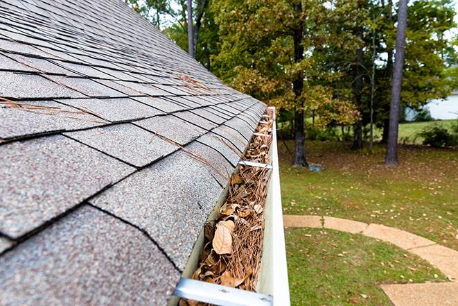 two workers cleaning gutter on a residential house